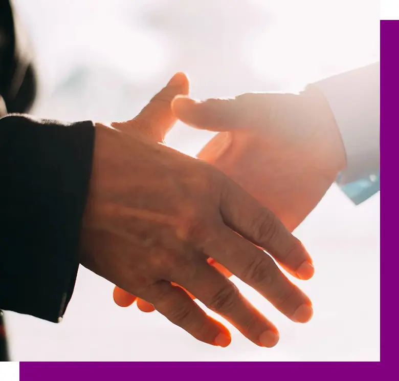 Two people shaking hands in front of a sky background